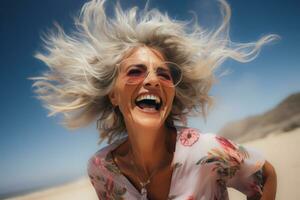 ai généré joyeux Sénior femme en riant sur ensoleillé plage avec vent dans cheveux photo