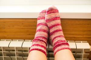 pieds dans chaud hiver chaussettes chaud en haut sur le radiateur. photo