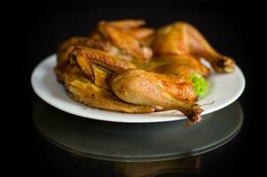 entier frit poulet dans une assiette sur une noir photo