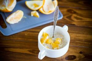 cuit bouilli sucré flocons d'avoine avec des oranges dans une bol photo