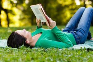femme jouit en train de lire livre dans parc photo