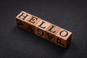 le une inscription Bonjour sur en bois cubes sur une foncé béton Contexte photo