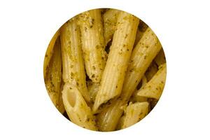 délicieux Frais Pâtes Penne avec vert Pesto sauce avec basilic, sel et épices photo