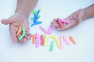 proche en haut homme mains détient petit coloré pâte à modeler pâte bars à faire Les figures. concept, Alzheimer, faible muscle les patients récupérer activité par sculpture. faire concentration. développer imagination. photo