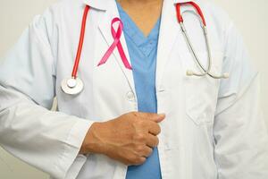 cancer du sein, femme médecin asiatique avec ruban rose, symbole de la journée mondiale du cancer du sein. photo