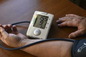 la mesure de du sang pression dans une retraité. une du sang pression moniteur pour humains. traitement de une retraité. photo