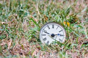 un vieux l'horloge dans le herbe photo