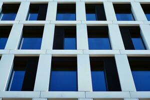 moderne Bureau bâtiment dans le ville avec les fenêtres et acier et aluminium panneaux mur. contemporain commercial architecture, verticale convergent géométrique lignes. photo