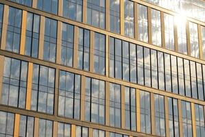 moderne Bureau bâtiment dans le ville avec les fenêtres et acier et aluminium panneaux mur. contemporain commercial architecture, verticale convergent géométrique lignes. photo