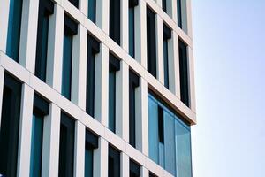 moderne Bureau bâtiment dans le ville avec les fenêtres et acier et aluminium panneaux mur. contemporain commercial architecture, verticale convergent géométrique lignes. photo