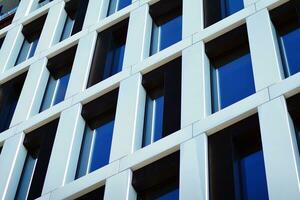 moderne Bureau bâtiment dans le ville avec les fenêtres et acier et aluminium panneaux mur. contemporain commercial architecture, verticale convergent géométrique lignes. photo