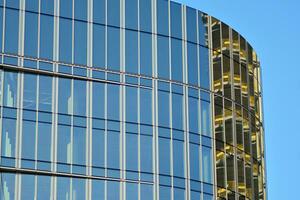 verre bâtiment avec transparent façade de le bâtiment et bleu ciel. de construction verre mur reflétant bleu ciel. abstrait moderne architecture fragment. contemporain architectural Contexte. photo