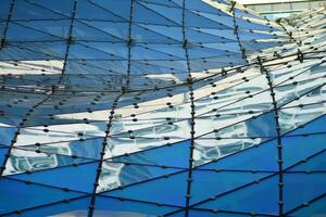 verre bâtiment avec transparent façade de le bâtiment et bleu ciel. de construction verre mur reflétant bleu ciel. abstrait moderne architecture fragment. contemporain architectural Contexte. photo