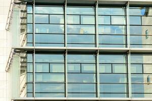 verre bâtiment avec transparent façade de le bâtiment et bleu ciel. de construction verre mur reflétant bleu ciel. abstrait moderne architecture fragment. contemporain architectural Contexte. photo