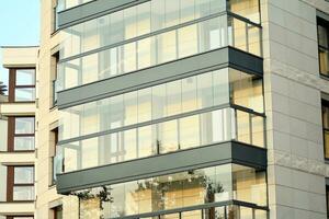 nouvel immeuble d'appartements avec balcons vitrés. maisons d'architecture moderne en bord de mer. grand vitrage sur la façade du bâtiment. photo