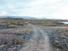 une saleté route dans le milieu de une désert avec montagnes dans le Contexte photo