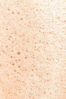 le texture de savon mousse avec bulles sur une pêche duvet Contexte. photo