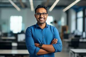 ai généré une Jeune Indien Masculin designer, ingénieur, architecte qui est portant des lunettes et une bleu chemise souriant permanent dans le Bureau et à la recherche à le caméra photo