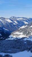 gratuit photo haute angle coup de une magnifique Montagne intervalle couvert avec neige en dessous de le bleu ciel