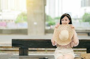 Jeune asiatique femme voyageur avec tissage panier attendre pour train dans train gare. périple voyage mode de vie, monde Voyage explorateur ou Asie été tourisme concept. photo