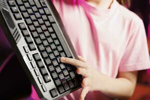 proche en haut coup de talentueux fille en présentant dernier jeu ordinateur périphérique technologie sur sa en ligne canaliser. concentrer sur sans fil Bluetooth mécanique clavier tenir par Jeune l'Internet étoile tournage la revue photo