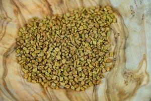 Fenugrec des graines entier ou sol sur olive bois photo