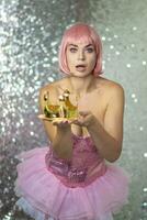 femme dans rose perruque avec or couronne. Halloween photo