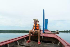 un adulte asiatique voyageur séance sur longue queue bateau. durabilité Voyage concept. photo