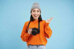 beauté et soins de la peau. proche en haut portrait de content souriant Japonais femme, touche sa clair, embrasé peau, Naturel en bonne santé affronter, permanent plus de bleu Contexte photo