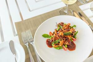 proche en haut de calamarata poulpe italien traditionnel sicilien Pâtes fait maison Fruit de mer sauce avec tomate, basilic, persil, herbes. gourmet nourriture dans bien à manger restaurant photo