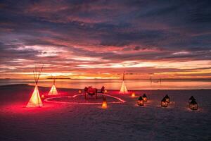 romantique le coucher du soleil dîner avec bougies cœur sur le mer le sable plage, rouge cœur forme formé dans sable. l'amour voyage de noces ou anniversaire dîner sur tropical plage photo