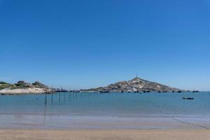 la mer sous le ciel bleu, des plages propres et de l'eau de mer, ainsi que des îles et des moulins à vent photo