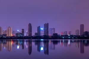une ville reflétée par le lac la nuit photo