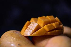 couper et compléter les mangues sur une assiette dans un environnement sombre photo