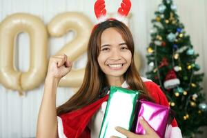 joyeux Noël 2024 concept asiatique femmes sont content et Enchanté à recevoir Noël cadeaux. photo