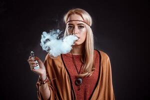 Jeune femme dans le boho style soufflant fumée photo
