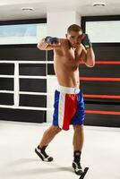 boxeur dans bleu gants chauffage en haut dans le Gym photo