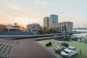 veille port avec navires dans Almere, Pays-Bas. ville centre dans le Matin lumière du soleil. rouge-rose ciel photo