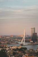 le coucher du soleil plus de le erasmusbrug pont dans le moderne ville de Rotterdam, Pays-Bas photo