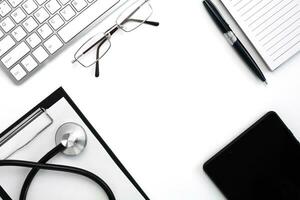 médical stéthoscope, clavier, carnet avec stylo et noir tablette sur blanc Contexte. médecins lieu de travail. Haut voir. flatlay composition. médical concept. photo