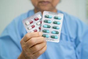 patiente asiatique âgée tenant des pilules de capsules d'antibiotiques dans un emballage blister pour le traitement d'une infection patient à l'hôpital, concept de pharmacie de pharmacie. concept de pharmacie pharmacie photo