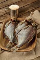 salé séchées au soleil dorades sur en bois assiette avec Bière dans métal agresser photo