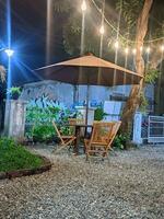 une patio avec une table et chaises en dessous de un parapluie photo