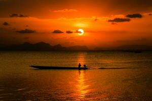 silhouettes de pêcheur à le Lac avec coucher de soleil, Thaïlande. photo