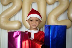 joyeux Noël 2024 concept garçon reçoit une cadeau de le sien mère à Noël photo