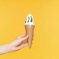 studio photo de élégant femme main diffusion devant tandis que offre Quelqu'un laiteux délicieux glace, je solated plus de Jaune Contexte. nourriture et bonbons concept