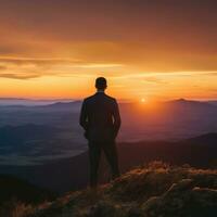 ai généré une la personne permanent sur une Montagne haut, à la recherche en dehors à une magnifique le coucher du soleil photo