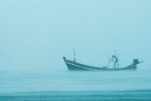 pêche bateau sur le mer avec il pleut dans le mer. photo