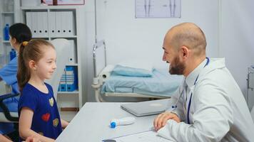 amical médecin Faire haute cinq avec enfant séance à le bureau. soins de santé médecin spécialiste dans médicament fournir santé se soucier prestations de service radiographique traitement examen dans hôpital cabinet photo