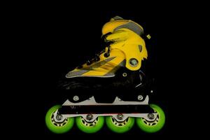 Jaune rouleau patins sur noir Contexte photo